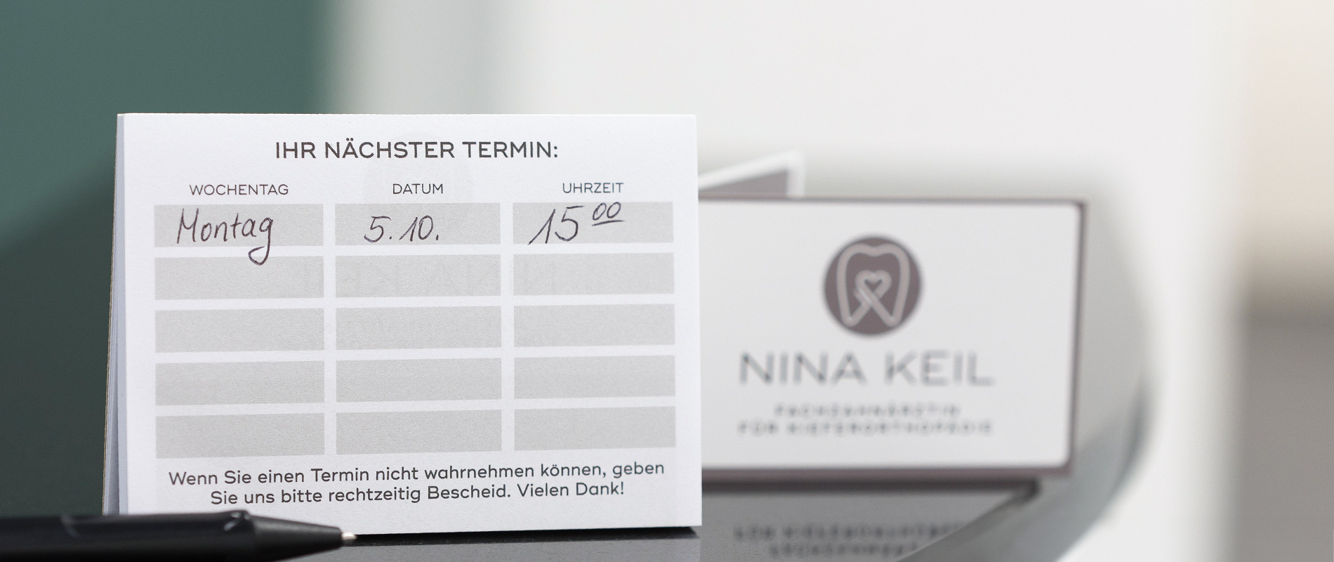 Aufnahme eines Terminzettels der Sprechzeiten der Praxis für Kieferorthopädie Nina Keil in Coburg